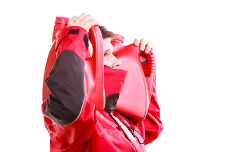 Man in oilskin with bottle fuel tank. Young male in waterproof jacket.の写真素材