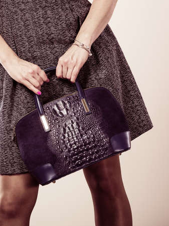 Fashion clothing people concept. Chic woman with black, leather handbag. Female wearing elegant dress.の写真素材