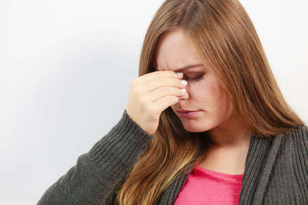 Sinus ache causing very paintful headache. Unhealthy woman in pain. Sharp strong sore.の写真素材
