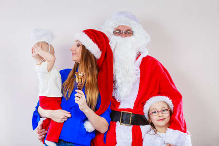 People, christmas time household concept. Happy family together with Santa Claus. Portrait of mother, daughters and Christmas Father.の写真素材
