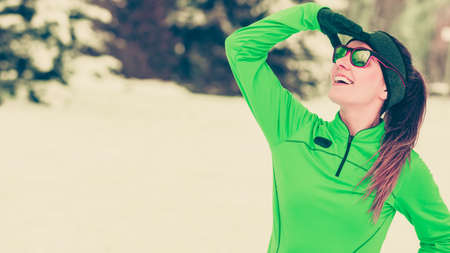 Sports activity in winter time, healthy lifestyle concept. Fit woman athlete girl training outdoor wearing warm sporty clothes in cold day snow weather. Toned imageの写真素材