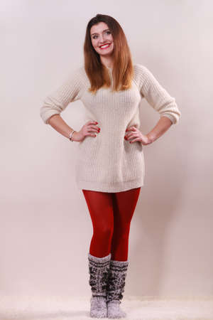 Winter fashion. Happy young woman in full length wearing fashionable wintertime clothes woolen warm sweater socks and red tightsの写真素材