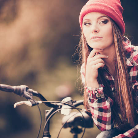 Fall active lifestyle concept,. Beauty young woman sporty casual girl relaxing in autumnal park with bicycle, outdoorの写真素材