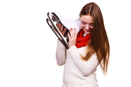 Woman with ice skates getting ready for ice skating, winter sport activity. Smiling cheerful girl wearing warm clothing on whiteの写真素材