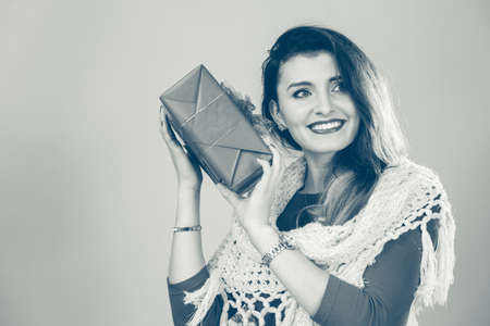 Cheerful woman holding present big gift box. Christmas season celebration concept.の写真素材