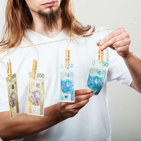 Riches and fortune. Young happy man with a lot of money on grey background. Winning the lottery concept.の写真素材