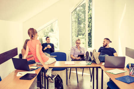 Highschool students having fun during a break in classroom interior