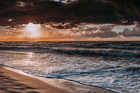 Amazing colorful sunset over evening sea horizon, clouds sky and sandy beach. Tranquil scene. Natural background. Landscape.の写真素材
