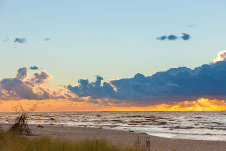 Amazing colorful sunset over evening sea horizon, clouds sky and sandy beach. Tranquil scene. Natural background. Landscape.の写真素材
