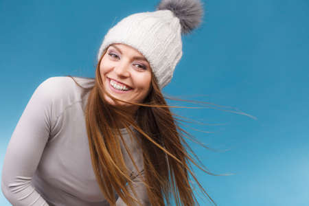 Attractive woman in winter wool cap and gray sports thermolinen underwear for skiing training studio...