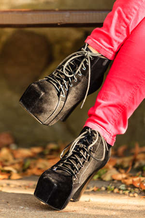 Female footwear. Part body woman wearing black elegant shoes high heels. Stylish girl in red...