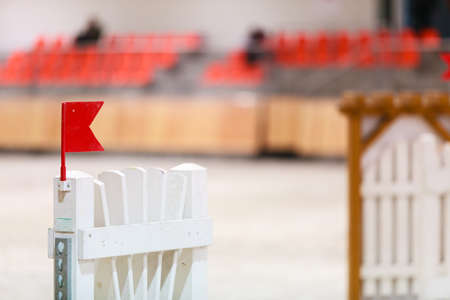 Equitation. Obstacle with red flag for jumping horses. Riding competition.