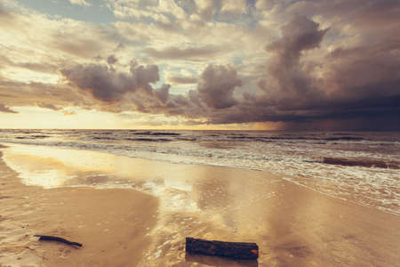 Amazing colorful sunset over evening sea horizon, clouds sky and sandy beach. Tranquil scene. Natural background. Landscape.の写真素材