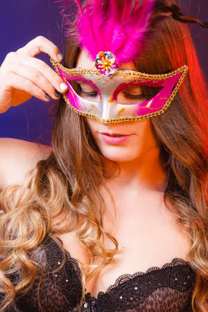 People, fashion, party concept. Sensual woman with carnival mask. Attractive young lady with long brown hair preaparing for celebration.の写真素材