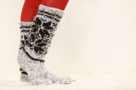 Winter fashion. Woman legs wearing fashionable wintertime clothes woolen warm socks and red tightsの写真素材