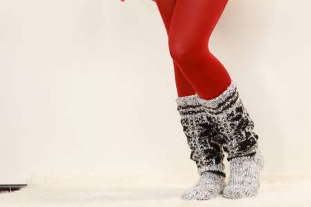 Winter fashion. Woman legs wearing fashionable wintertime clothes woolen warm socks and red tightsの写真素材