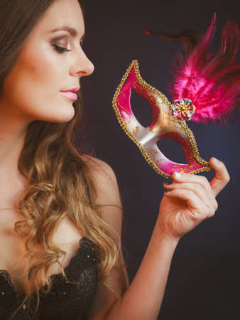 Sensuality celebrations people concept. Sensual lady holding carnival mask. Young woman has amazing and delicate make up.の写真素材