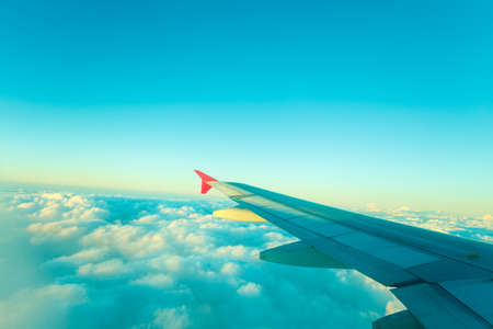 Adventure, travel, transport concept. View from plane window at sky with clouds and wingの写真素材