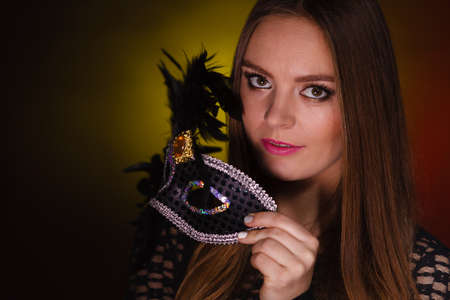 Sensuality celebrations people concept. Sensual lady holding carnival mask. Young woman has amazing and delicate make up.の写真素材