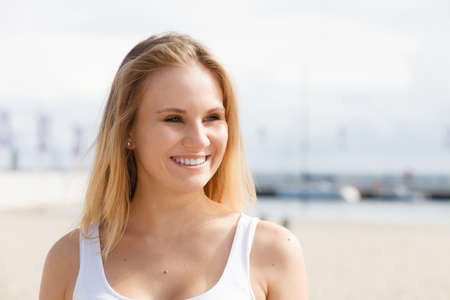 Gorgeous lovely blondie girl portrait. Attractive happy cute girl in white t-shirt on marina place.の写真素材
