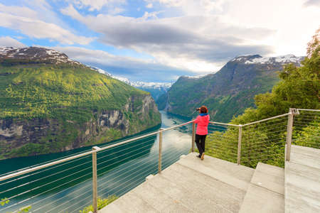 Tourism vacation and travel. Female tourist enjoying beautiful view over magical Geirangerfjorden...