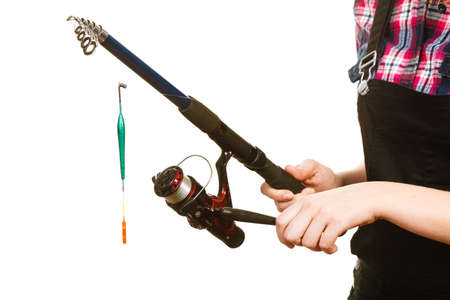 Fishing equipment concept. Woman holding fishing rod with green float. Isolated background.の写真素材