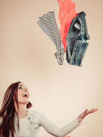 Lifestyle and clothing love for fashion. Young female with outstretched arms throw colorful garment in air.の写真素材