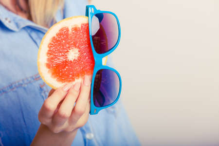 Summer girl holding grapefruit. Happy tourist enjoyed vacation.の写真素材