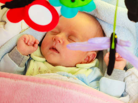 Little newborn baby in pyjamas lying on back and sleeping in bedding. Family, parenthood, childhood...