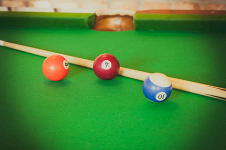 Billiard balls and cue stick on green table. Pool gameの写真素材
