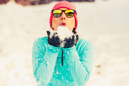 Young female holding snow. Relax fun in winter park. Health nature fashion fitness concept.の写真素材