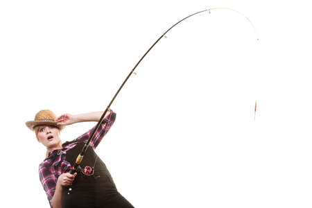 Spinning equipment, angling, cheerful fisherwoman concept. Happy woman in sun hat holding fishing rod, having fun while hunting for fishの写真素材