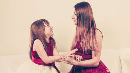 Play and fun. Charming little girl making funny crazy face with joyful mother. Smiling lovely cute female child and woman. Positive facial emotion.の写真素材