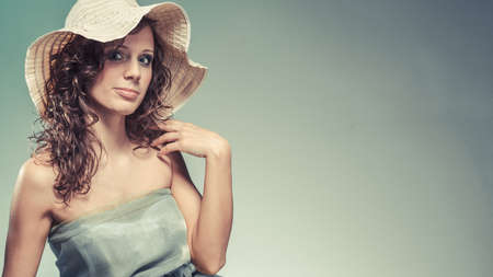 Fashion, cosmetics and summertime. Modern young woman with light green dress and summer hat.の写真素材