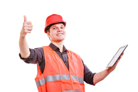Technological development in company. Young handsome man worker in safety vest and hard hat with...