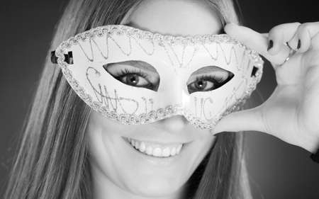 People, fashion, party concept. Sensual woman with carnival mask. Attractive young lady with long brown hair preaparing for celebration.の写真素材