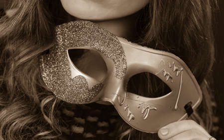 Holidays, people and celebration concept. Female hand holding carnival mask closeup, black and white photoの写真素材