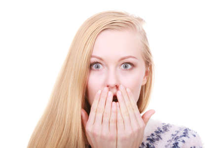 Face expression, human emotions concept. Shocked and surprised young blonde woman covering mouth with her hand.の写真素材