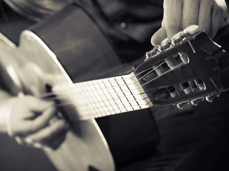 Music hobby people concept. Male hands with guitar. Musician playing the wooden instrument.