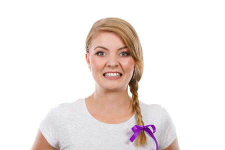 Face expression, adolescence problems concept. Teenage girl in blonde braid hair making angry face.の写真素材