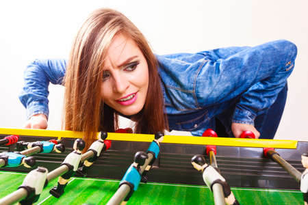 Play and fun concept. Young woman girl having fun with table soccer game. Girl playing spending free time on recreation.の写真素材
