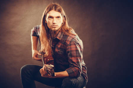 Guitarist trying out chords. Young male musican practicing on guitar. Music instrument passion concept.の写真素材