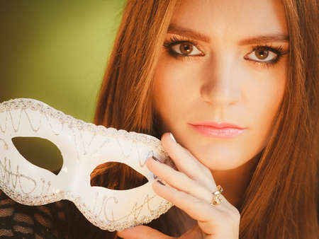 Diguise party celebration concept. Portrait of young charming woman in artistic image posing with mask.の写真素材