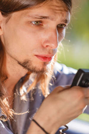 Talking while drive, auto walkie talkie, comunication concept. Young man driving car using cb radioの写真素材