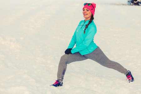 Woman exercising among snow and ice, how to work out in cold environment, fitness nature fashion conceptの写真素材