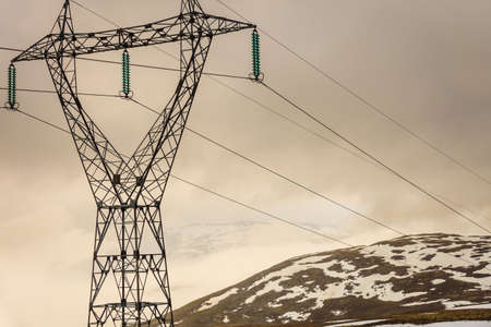 electricity pylons power lines high voltage towers in norwegian mountains landscape, hazy rainy day, hiking area between aurland and lærdal in norwayの写真素材