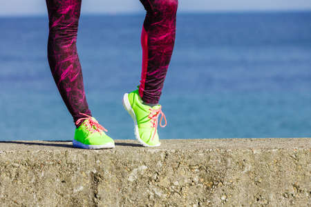 Sports and activities. Part body of training active sporty girl outside. Slim fit legs in vivid...