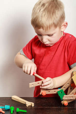 Spending free time play and education for children. Little boy in red shirt play with colorful toy on table.の写真素材
