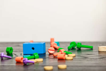 Education and childhood. Toy for kids preschool training. Colorful wooden screw and block  on wood table.の写真素材