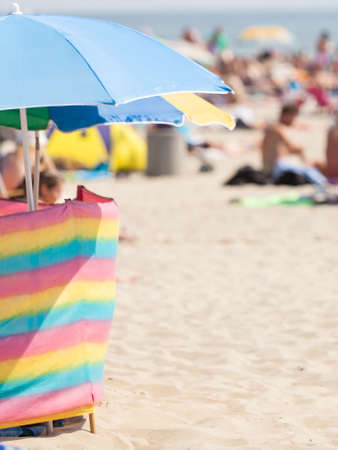Sunbathing equipment concept. Opened sun protective umbrella on sandy beach during summertimeの写真素材